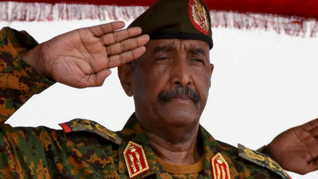 Sudan's General Abdel Fattah al-Burhan salutes as he listens to the national anthem after landing in the military airport of Port Sudan on his first trip away following the crisis in Sudan's capital Khartoum since an internal conflict broke out, in the city of Port Sudan, Sudan, August 27, 2023