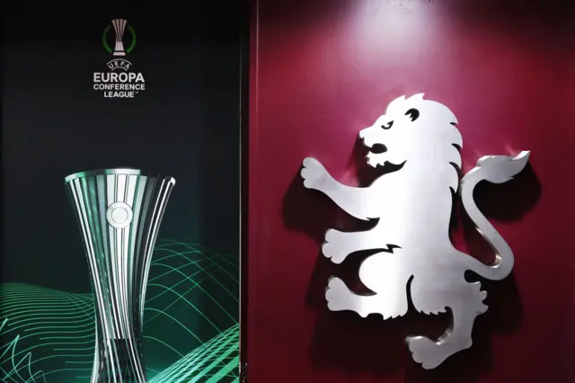 Aston Villa badge next to the Europa Conference League logo.