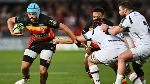 Zach Mercer of Gloucester Rugby is challenged by Morgan Morris of Ospreys