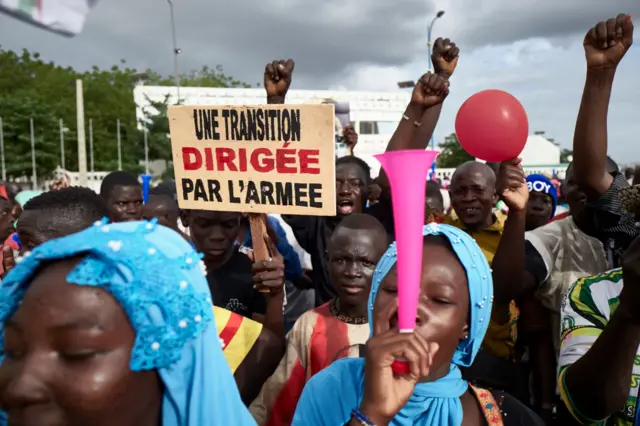 A man holds a sign reading "A transition led by the army" as supporters of the CNSP (National Committee for the Salvation of the People) take part in a rally on Independence square in Bamako, on September 8, 2020, following a call by the MP4 (Popular Movement of 4th September) for a gathering to support the role of the army in Mali's transition phase after a military junta overthrew the president.