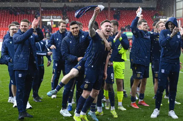 Dundee players celebrate on the Pittodrie pitch