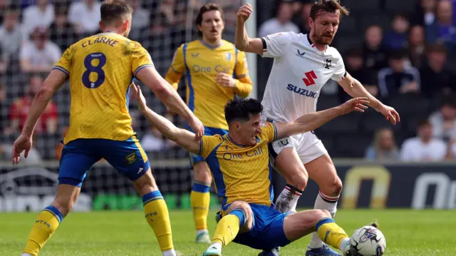 MK Dons' Alex Gilbey tussles with Mansfield's George Williams