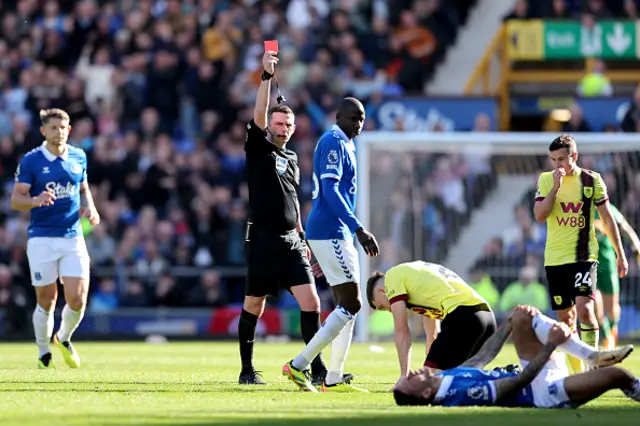 Referee Michael Oliver gives a red card to Dara O'Shea