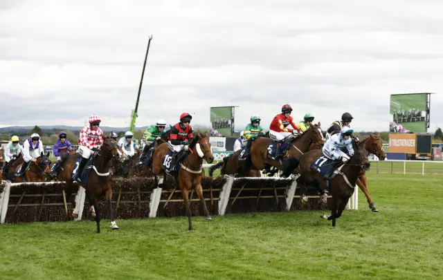 Horses jump a fence during the William Hill Handicap Hurdle at Aintree