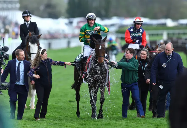 Jockey Paul Townend pours a bucket of water over Grand National winner I Am Maximus