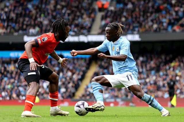 Jeremy Doku of Manchester City is challenged by Fred Onyedinma