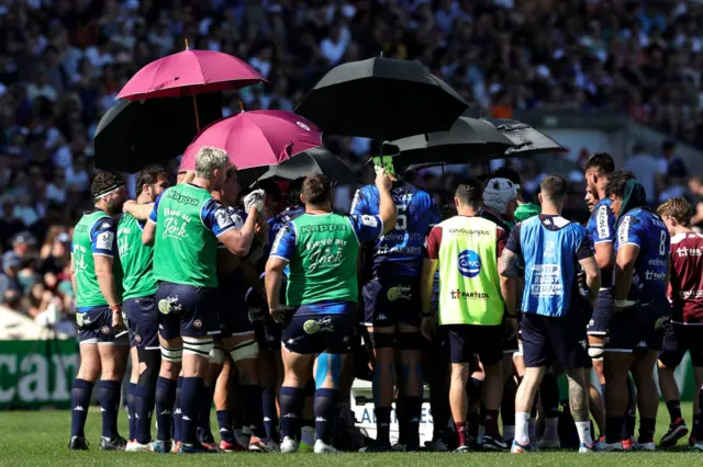 Bordeaux players under umbrellas