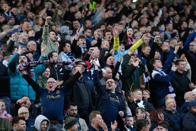 Dundee fans celebrate some welcome news at Pittodrie