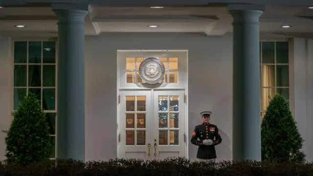 A Marine is posted outside the West Wing entrance of the White House, indicating that President Biden is present, in Washington, D