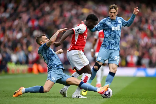 Bukayo Saka is tackled by Lucas Digne