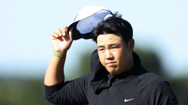 Tom Kim doffs his cap at the 2024 Masters