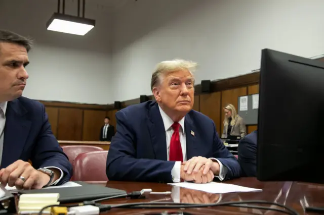 Trump looking up at the judge in court