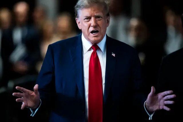 Trump speaks outside a Manhattan courtroom in a blue suit and red tie