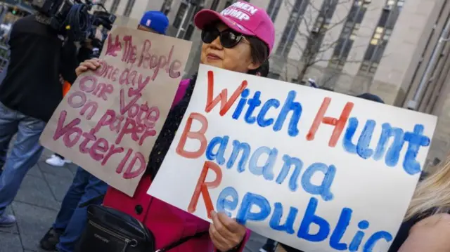 A Trump supporter holds signs supporting him