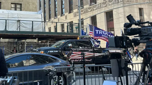 A truck with Trump flags drives around the New York courthouse