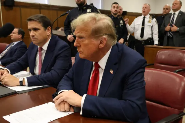 Donald Trump seated next to his attorney Todd Blanche