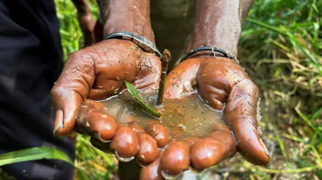 A man shows his hands covered in crude oil mixed with lake water in Ikarama community, Okordia Kingdom of Yenagoa local government area, Bayelsa State, Nigeria February 8, 2024.