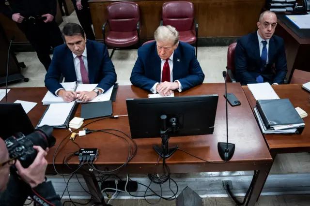 Donald Trump (C) appears with his legal team Todd Blanche, and Emil Bove (R) ahead of the start of jury selection