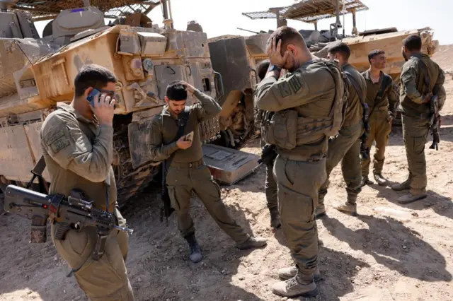 Israeli soldiers gather on Monday next to military vehicles near the Israel-Gaza border