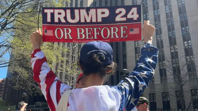 A Trump supporter holds a sign up supporting his 2024 presidency campaign