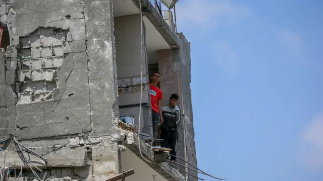 Two males looking out from a destroyed building in Gaza