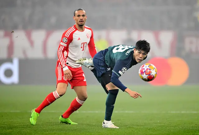 Leroy Sane of Bayern Munich and Takehiro Tomiyasu of Arsenal watch a loose ball d