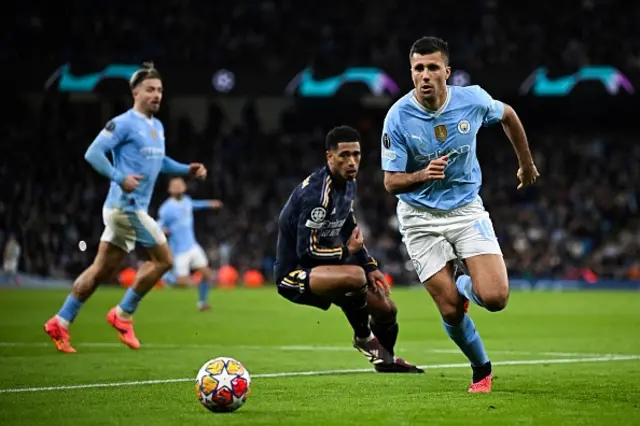 Rodri (R) controls the ball past Real Madrid's English midfielder #5 Jude Bellingham