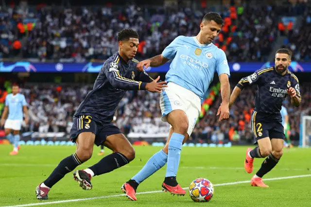 Rodri of Manchester City competes with Jude Bellingham