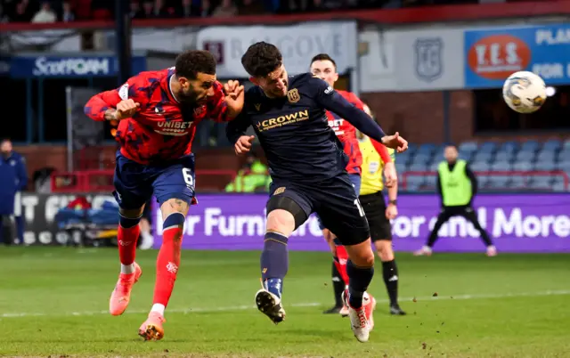 Rangers Connor Goldson has a header on target under pressure from Dundee's Ricki Lamie during a cinch Premiership match between Dundee and Rangers at the Scot Foam Stadium at Dens Park