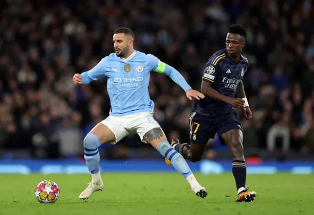 Kyle Walker of Manchester City runs with the ball whilst under pressure from Vinicius Junior