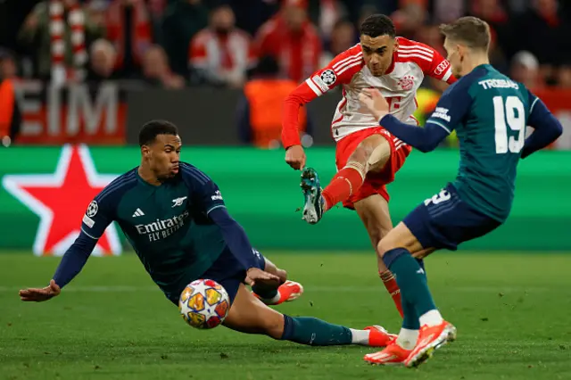 Jamal Musiala (R) gets a shot away past Arsenal's Brazilian defender #06 Gabriel Magalhaes