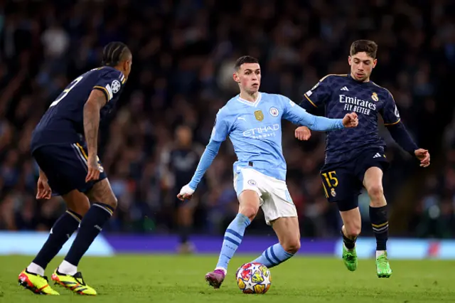 Phil Foden of Manchester City (C) is challenged by Federico Valverde