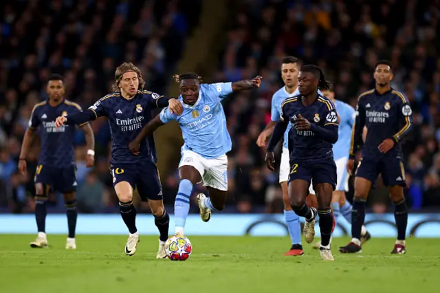 Luka Modric of Real Madrid (L) and Jeremy Doku of Manchester City battle for the ball