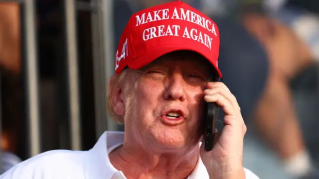 Former president Donald Trump speaks on the phone at the 18th green during day three of the LIV Golf Invitational