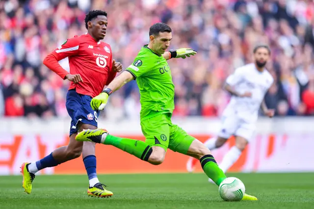 Emiliano Martinez of Aston Villa passes the ball whilst under pressure from Jonathan David