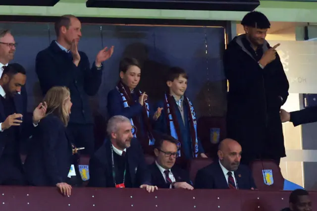 Prince William and Prince George clapping in football stands