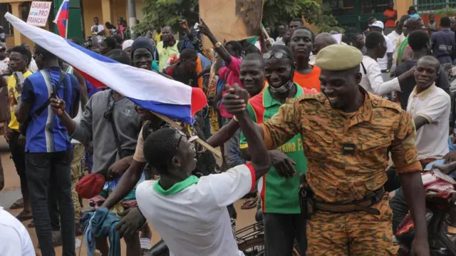 A man and a solider shake hands during a rally in support of the coup in Ouagadougou, Burkina Faso, 02 October 2022.