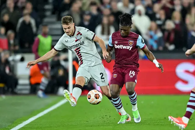 Josip Stanisic of Bayer 04 Leverkusen and Mohammed Kudus battle for the ball