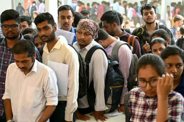 Job seekers wait to attend a walk-in-interview during a state-level job fair organised by India's Karnataka state government at the Palace Grounds in Bengaluru on February 26, 2024.