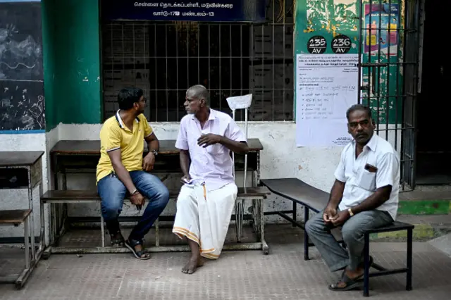 Men wait to cast their votes at a polling station as voting starts in the first phase of India's general election in Chennai