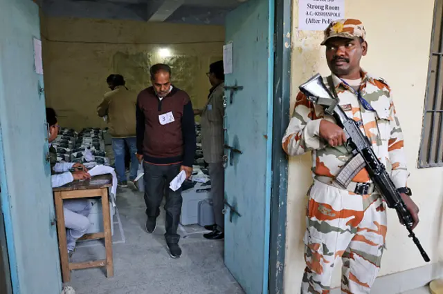 A security personnel is standing guard outside a strong room, where EVMs are being kept