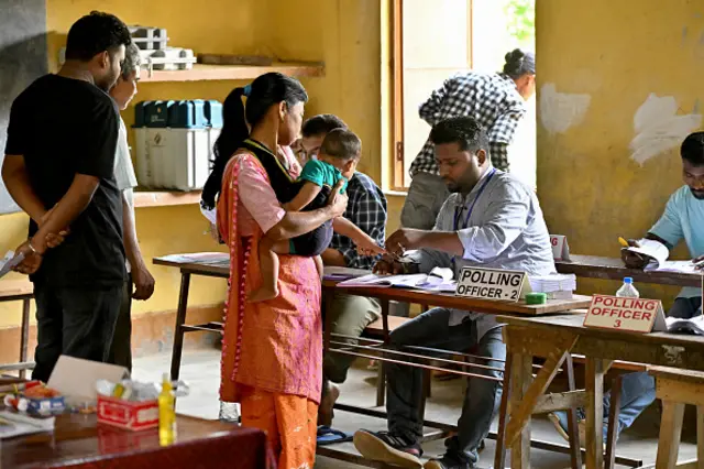 A polling official marks the finger of a woman with indelible ink after she cast her ballot to vote in the first phase of India's general election at a polling station at Nagaon district, in the country's northeastern state of Assam