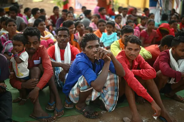 Voters gather outside a polling station to cast their ballot during the first phase of voting for the India's general election, in Dugeli village of Dantewada district of Chhattisgarh