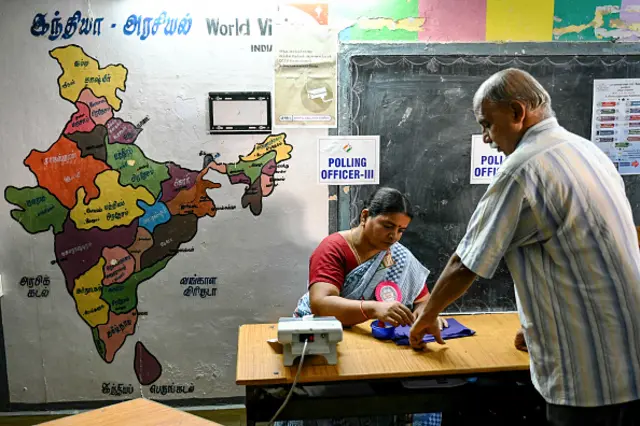 A man (R) has his finger marked with ink after casting his vote at a polling station as voting starts during the first phase of India's general election in Chennai