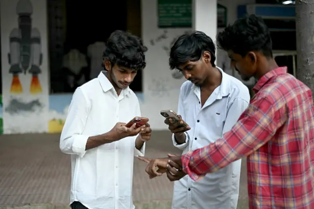 People take pictures after casting their ballots to vote at a polling station as voting starts in the first phase of the India's general election in Chennai, capital of India's Tamil Nadu state on April 19, 2024