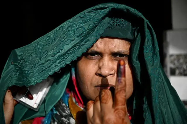 A woman shows her inked finger after casting her ballot to vote in the first phase of India's general election at a polling station in Kairana, Shamli district, in India's Uttar Pradesh state