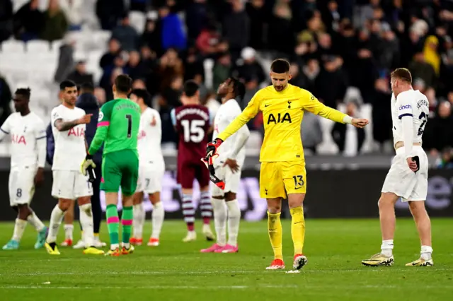 Spurs players stand dejected on the pitch at full time