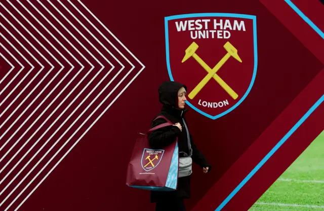 A west ham fan carrying a merchandise bag outside the stadium