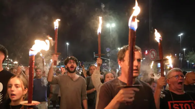 People holding sticks with fire protesting