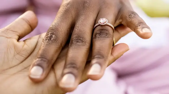 Close-up of a bride hand showing her engagement ring to a friend at bridal shower